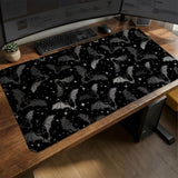 Black desk mat with a dark bat pattern and scattered stars on a charcoal background.