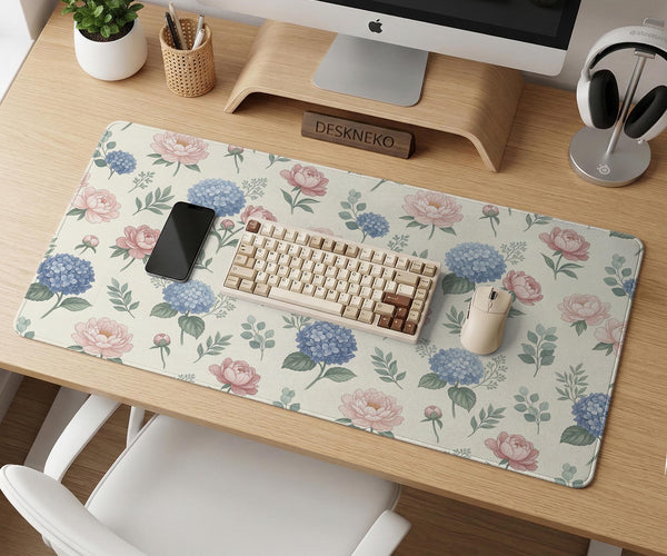 Floral desk mat with sage greenery, pink peonies, blue flowers, and a warm cream background.