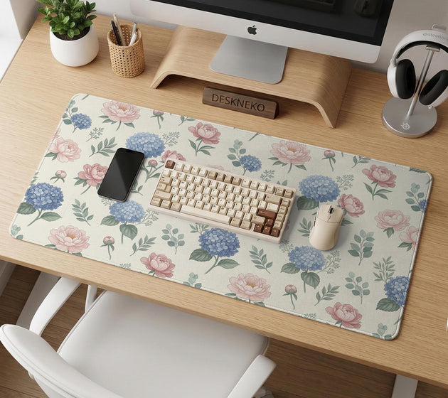 Floral desk mat with sage greenery, pink peonies, blue flowers, and a warm cream background.