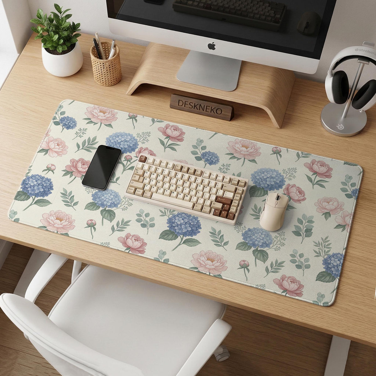 Floral desk mat with sage greenery, pink peonies, blue flowers, and a warm cream background.