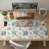 Floral desk mat with sage greenery, pink peonies, blue flowers, and a warm cream background.