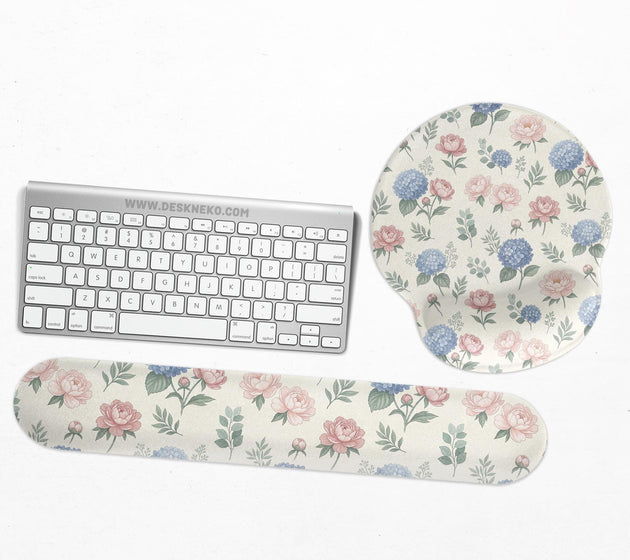 Mousepad and keyboard wrist rest with a floral print of blue hydrangeas, pink peonies, sage leaves, and a cream background.