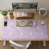 Lavender desk mat with an all-over pattern of bunny faces, clouds, moons, bows, and flowers in pastel colors.