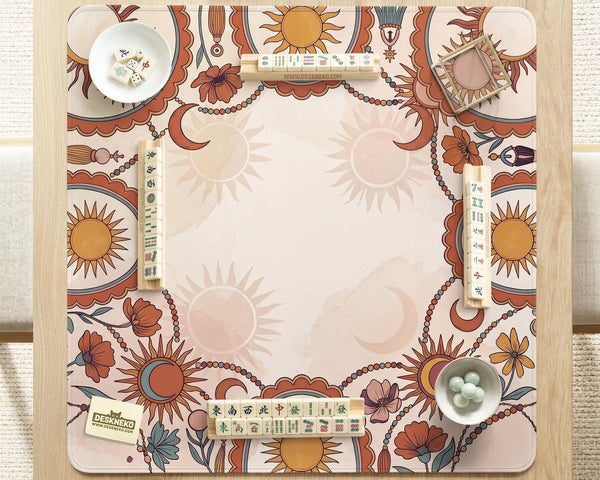A square mahjong mat with a scalloped edge, sun and moon artwork, terracotta flowers, a soft cream background, and a decorative border around the play area.
