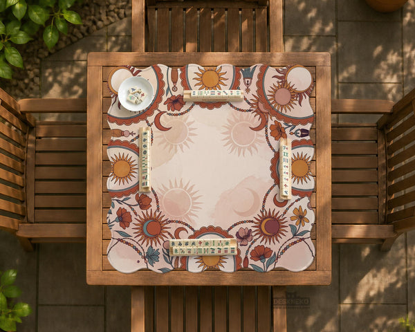 A square mahjong mat with a scalloped edge, sun and moon artwork, terracotta flowers, a soft cream background, and a decorative border around the play area.