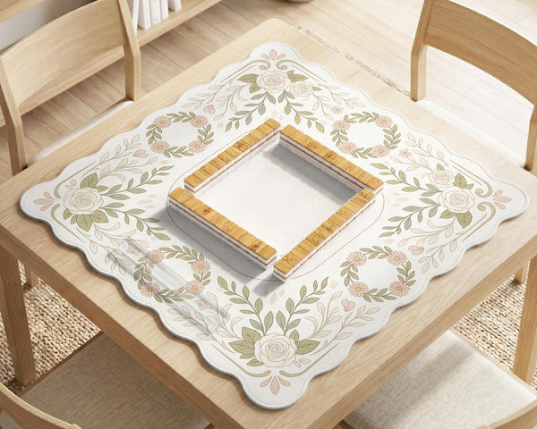 Square mahjong mat with a light floral border in sage green, cream, and blush around a plain center play area.
