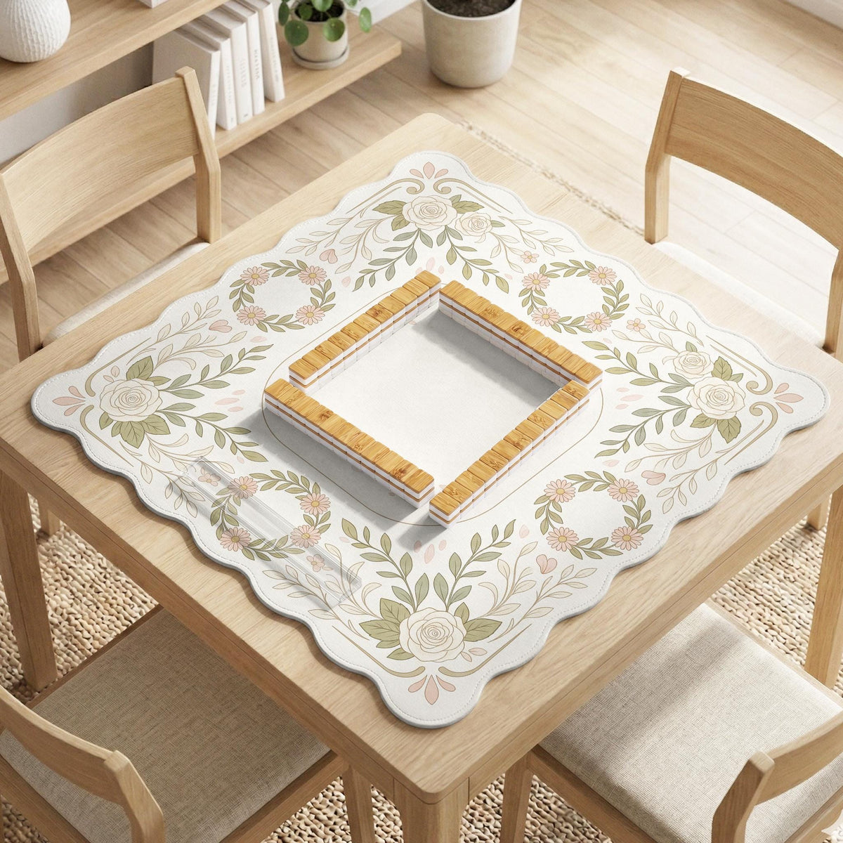 Square mahjong mat with a light floral border in sage green, cream, and blush around a plain center play area.
