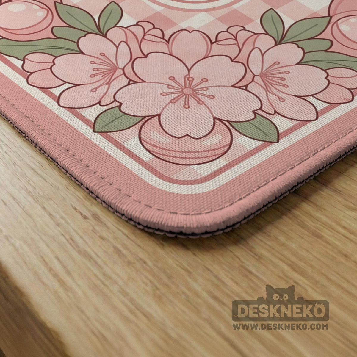 Pink gingham mahjong mat with a floral border, cherry blossom details, and a bow design around a plain center play area.