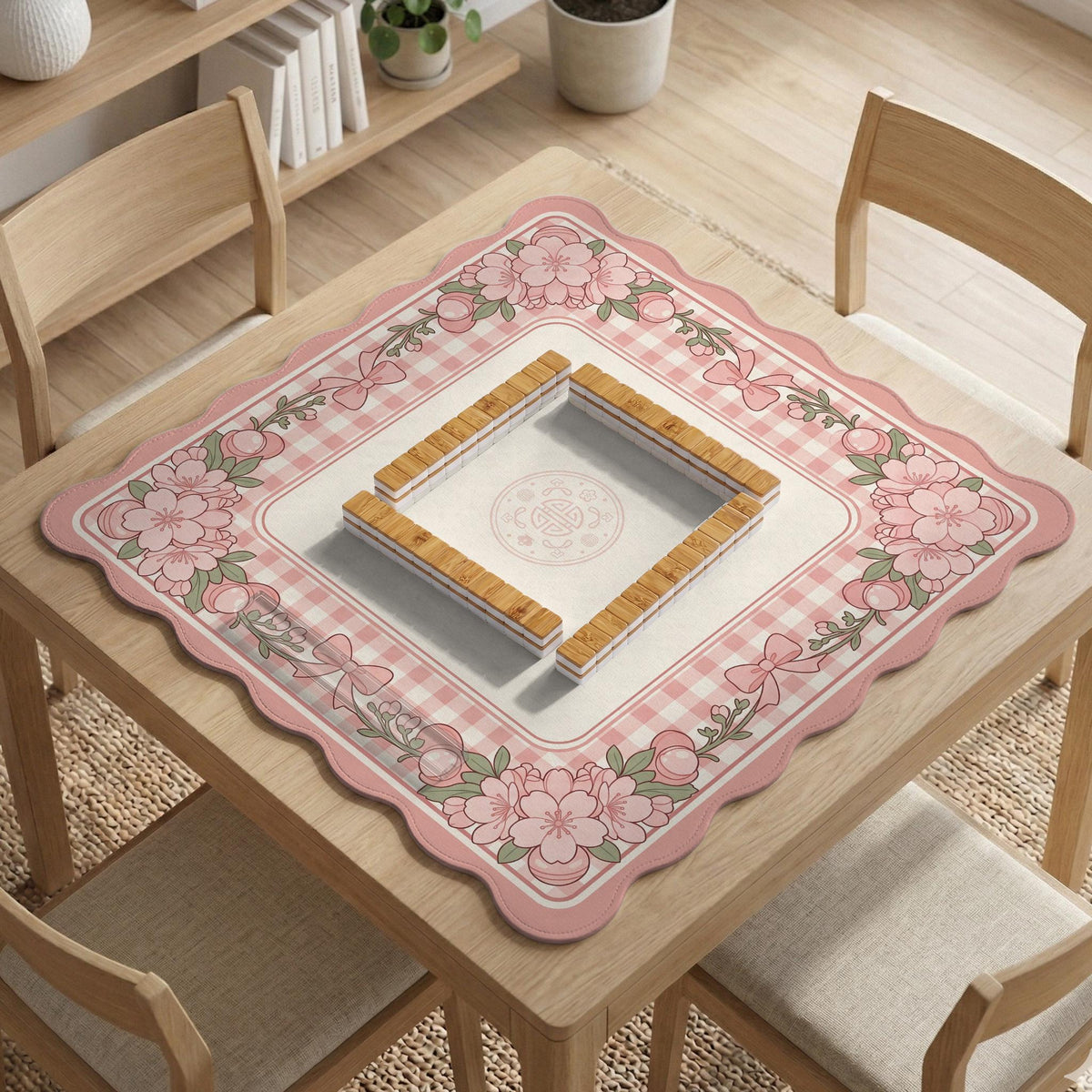 Pink gingham mahjong mat with a floral border, cherry blossom details, and a bow design around a plain center play area.