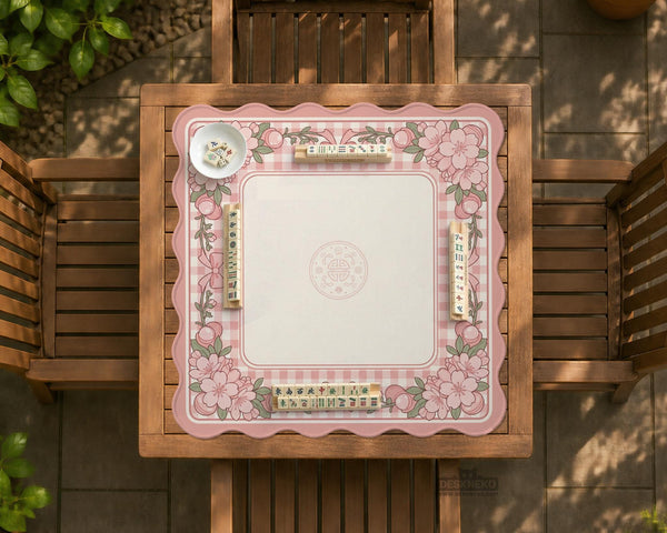 Pink gingham mahjong mat with a floral border, cherry blossom details, and a bow design around a plain center play area.