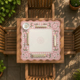 Pink gingham mahjong mat with a floral border, cherry blossom details, and a bow design around a plain center play area.