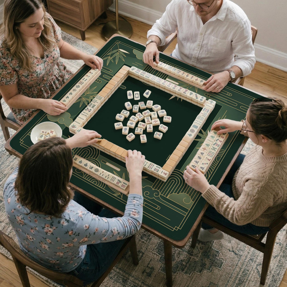 Square emerald green mahjong mat with bamboo line art, gold geometric cloud shapes, and a plain center playing area.