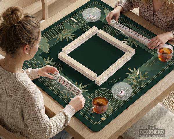 Square emerald green mahjong mat with bamboo line art, gold geometric cloud shapes, and a plain center playing area.