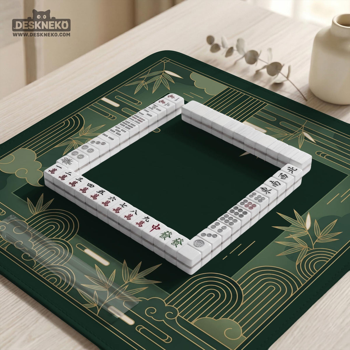 Square emerald green mahjong mat with bamboo line art, gold geometric cloud shapes, and a plain center playing area.