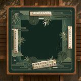 Square emerald green mahjong mat with bamboo line art, gold geometric cloud shapes, and a plain center playing area.