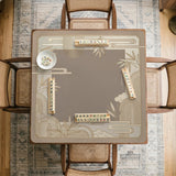 Beige and gold square mahjong mat with a bamboo pattern and geometric border.