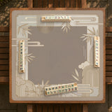 Beige and gold square mahjong mat with a bamboo pattern and geometric border.
