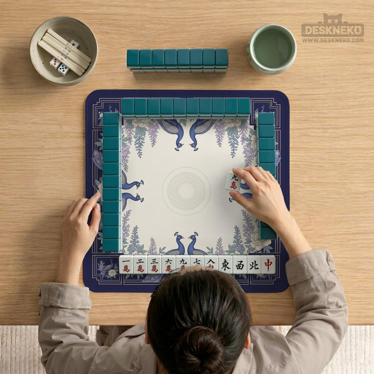 Blue mahjong table mat with a peacock and floral border, ivory center, lavender flowers, and scalloped edges.