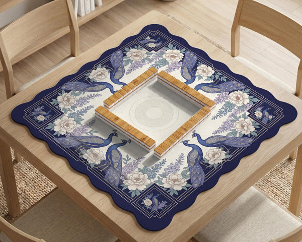 Blue mahjong table mat with a peacock and floral border, ivory center, lavender flowers, and scalloped edges.