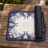 Blue mahjong table mat with a peacock and floral border, ivory center, lavender flowers, and scalloped edges.