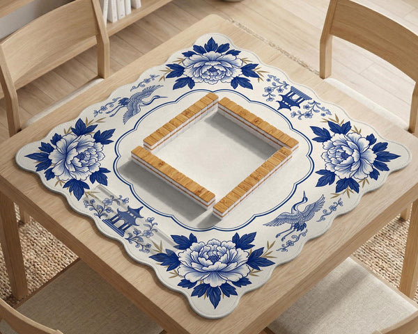 Blue and white mahjong mat with cranes, floral porcelain-style artwork, a cream center area, and a decorative border.