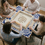Blue and white mahjong mat with cranes, floral porcelain-style artwork, a cream center area, and a decorative border.
