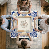 Blue and white mahjong mat with cranes, floral porcelain-style artwork, a cream center area, and a decorative border.