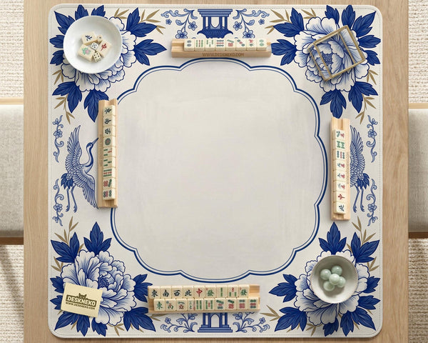 Blue and white mahjong mat with cranes, floral porcelain-style artwork, a cream center area, and a decorative border.