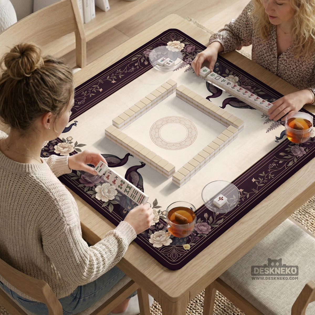 Square mahjong mat with a dark plum border, ivory floral pattern, muted sage leaves, and a decorative peacock garden design.