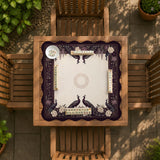 Square mahjong mat with a dark plum border, ivory floral pattern, muted sage leaves, and a decorative peacock garden design.