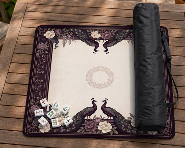 Square mahjong mat with a dark plum border, ivory floral pattern, muted sage leaves, and a decorative peacock garden design.