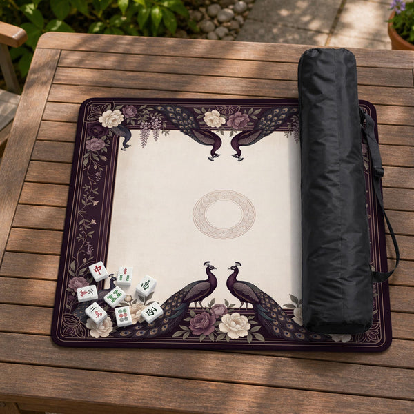 Square mahjong mat with a dark plum border, ivory floral pattern, muted sage leaves, and a decorative peacock garden design.