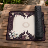 Square mahjong mat with a dark plum border, ivory floral pattern, muted sage leaves, and a decorative peacock garden design.