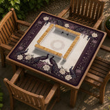 Square mahjong mat with a dark plum border, ivory floral pattern, muted sage leaves, and a decorative peacock garden design.