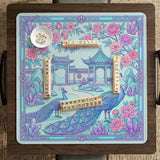 Pastel aqua mahjong table mat with peacock birds, pink flowers, pavilion details, and ornate floral linework.