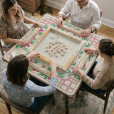 Pink cherry blossom floral mahjong table mat with a cream center and bamboo-style border design.