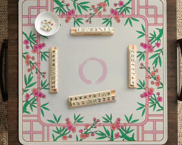 Pink cherry blossom floral mahjong table mat with a cream center and bamboo-style border design.