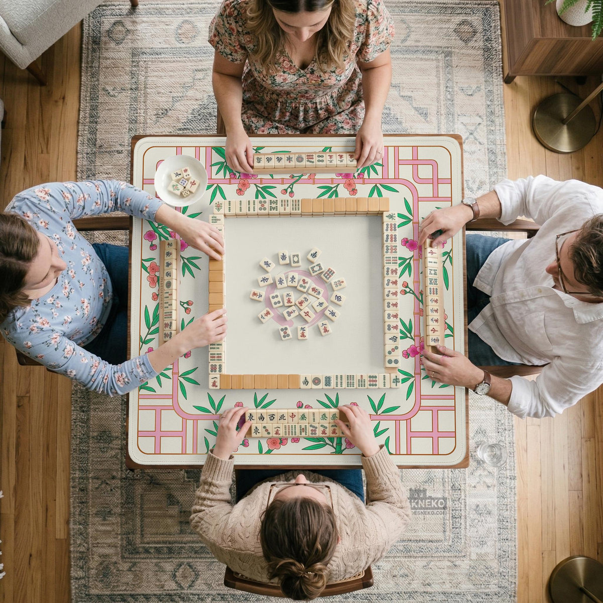 Pink cherry blossom floral mahjong table mat with a cream center and bamboo-style border design.