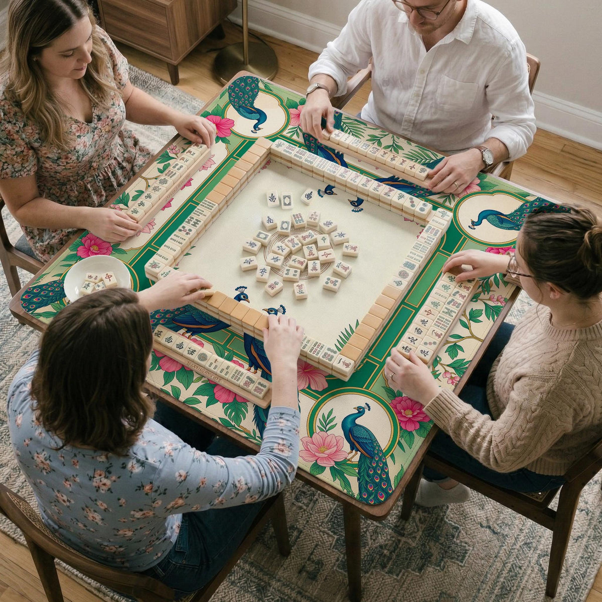 Green mahjong mat with peacocks, hibiscus flowers, tropical leaves, cream center space, and a scalloped floral border.