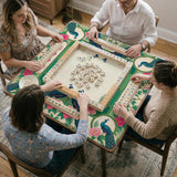 Green mahjong mat with peacocks, hibiscus flowers, tropical leaves, cream center space, and a scalloped floral border.