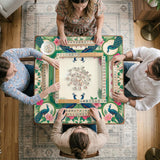 Green mahjong mat with peacocks, hibiscus flowers, tropical leaves, cream center space, and a scalloped floral border.