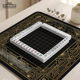 Black and gold square mahjong mat with a scalloped edge, geometric border, thin line details, fan motifs, and dragon and phoenix accents around an open center.