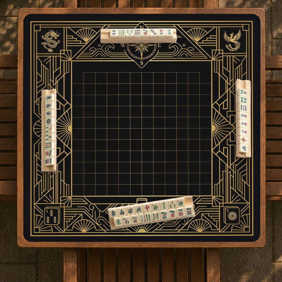 Black and gold square mahjong mat with a scalloped edge, geometric border, thin line details, fan motifs, and dragon and phoenix accents around an open center.