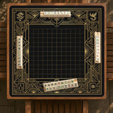 Black and gold square mahjong mat with a scalloped edge, geometric border, thin line details, fan motifs, and dragon and phoenix accents around an open center.
