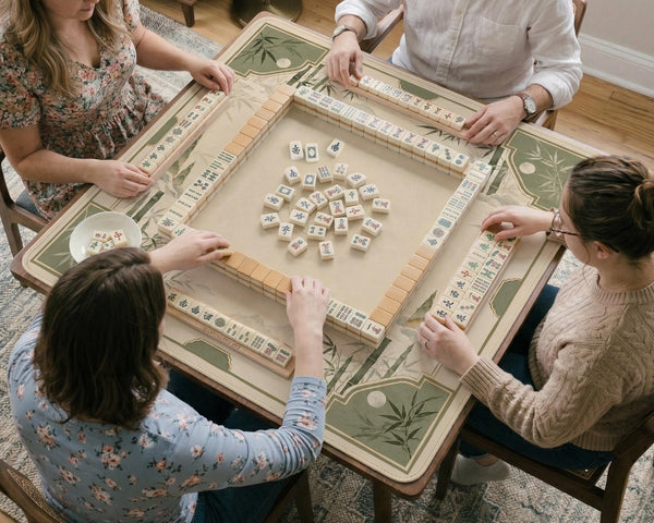 Square mahjong mat with a sage green bamboo and mountain design, cream center, scalloped border details, and gold line accents.