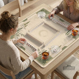 Square mahjong mat with a sage green bamboo and mountain design, cream center, scalloped border details, and gold line accents.