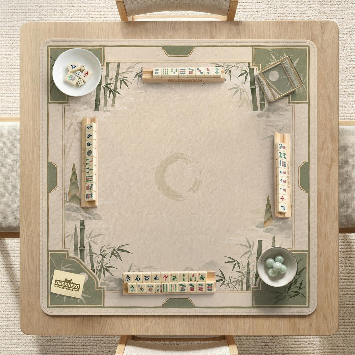 Square mahjong mat with a sage green bamboo and mountain design, cream center, scalloped border details, and gold line accents.