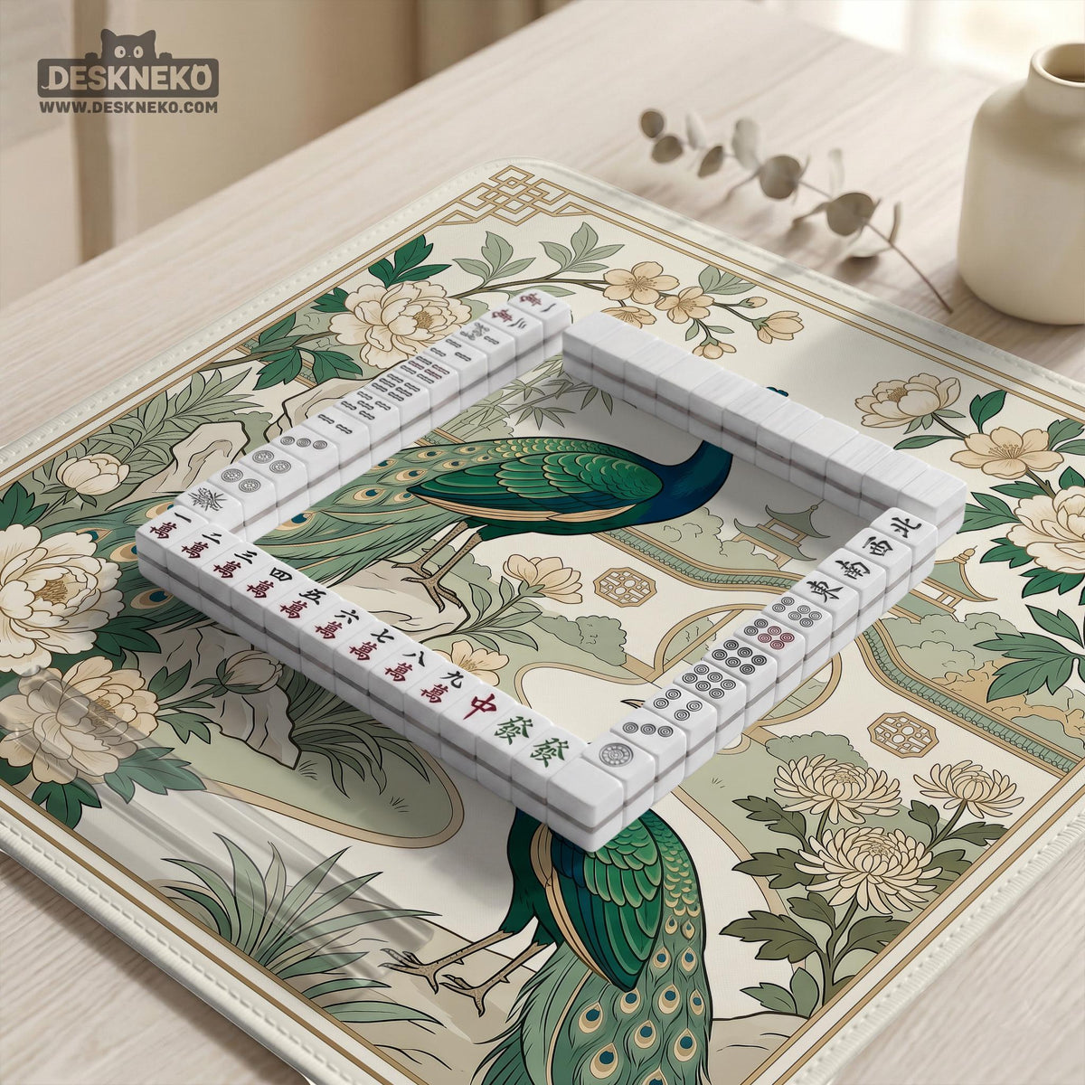 A green mahjong mat with peacock, floral, bamboo, pagoda, and gold border artwork in a scalloped chinoiserie style.