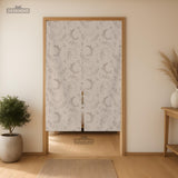 Beige door curtain with a crescent moon, leafy botanical branches, gray line art, and dotted celestial details.