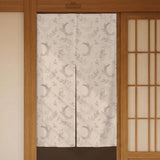 Beige door curtain with a crescent moon, leafy botanical branches, gray line art, and dotted celestial details.